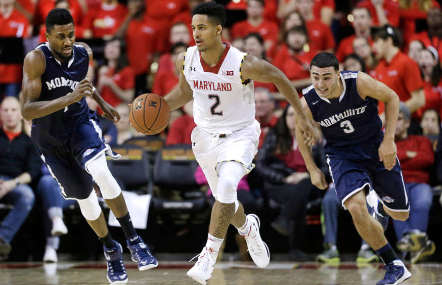 Maryland guard Melo Trimble, center, drives past Monmouth forward Brice Kofane, back left, and guard Max DiLeo in the second half of an NCAA college basketball game, Friday, Nov. 28, 2014, in College Park, Md.
