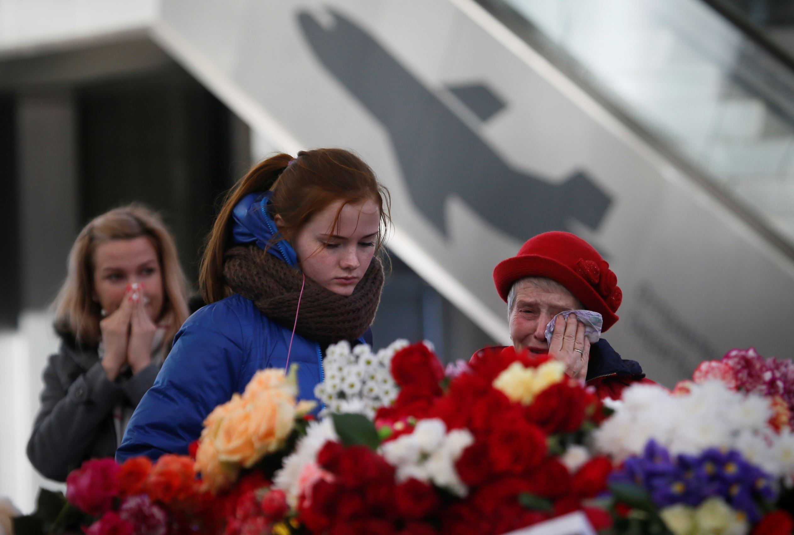 People react, at an entrance of Pulkovo airport during a day of national mournin...