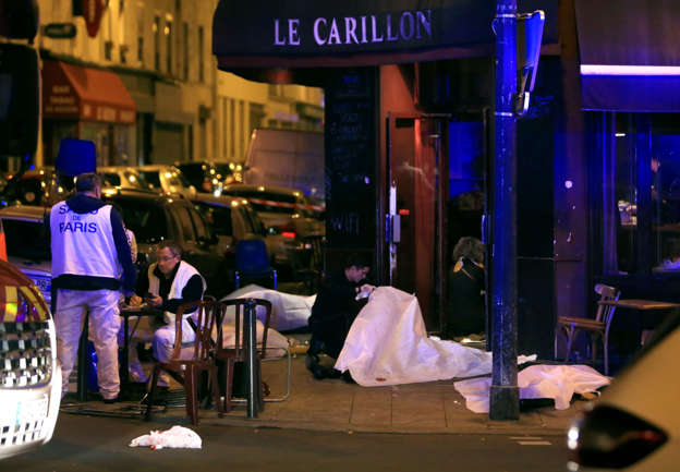 Victims lay on the pavement in a Paris restaurant, Friday, Nov. 13, 2015. Police officials in France on Friday reported a shootout in a Paris restaurant and an explosion in a bar near a Paris stadium. It was unclear if the events were linked.
