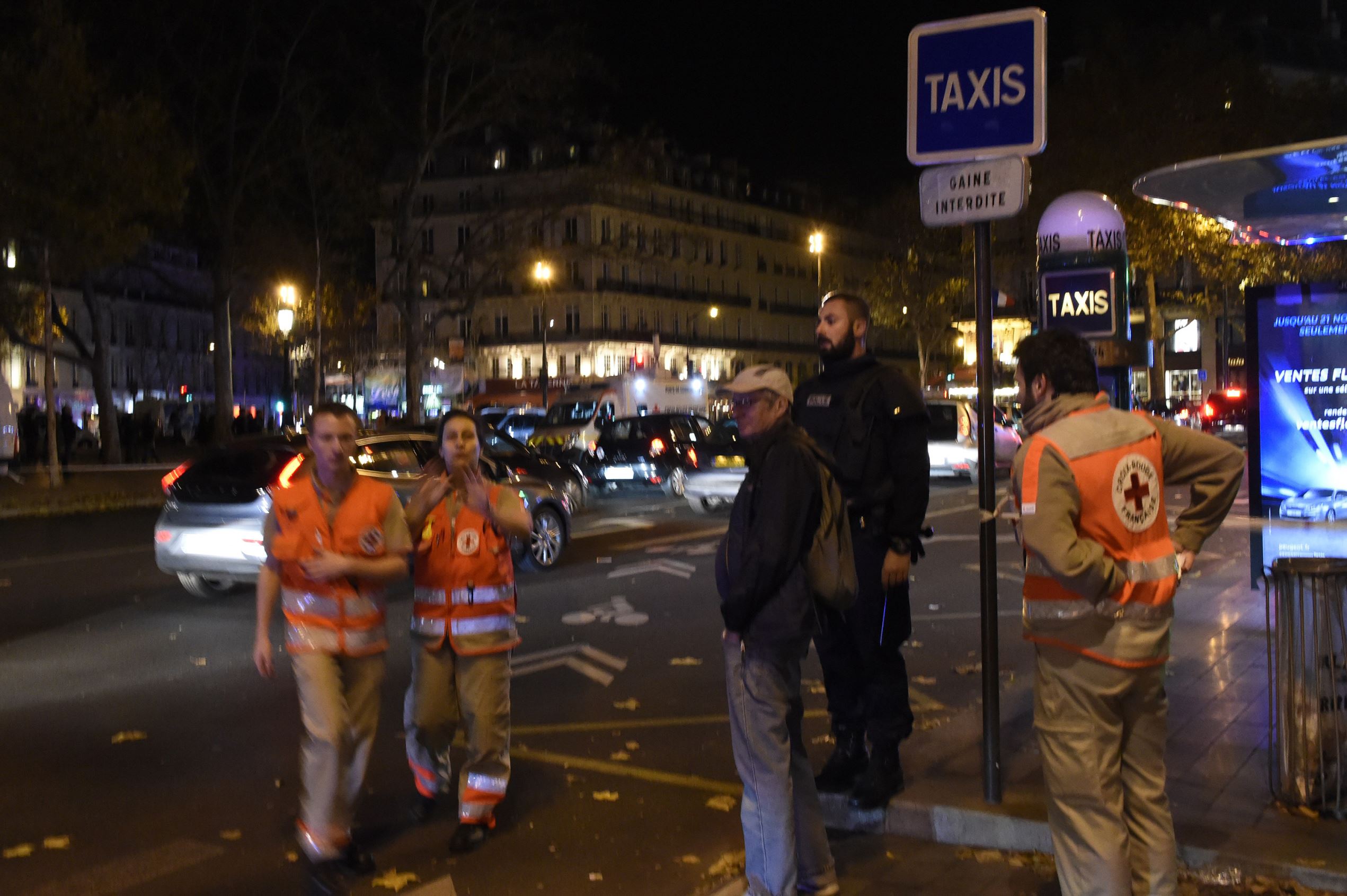 Rescue workers run after hearing what is believed to be explosions or gun shots near Place de la Republique square in Paris on November 13, 2015. At least 18 people were killed in several shootings and explosions in Paris today, police said. AFP PHOTO / DOMINIQUE FAGET (Photo credit should read DOMINIQUE FAGET/AFP/Getty Images)