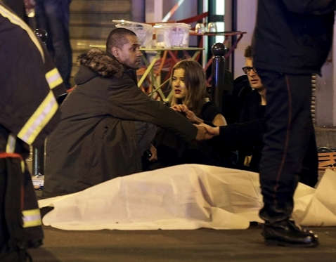ATTENTION EDITORS - VISUAL COVERAGE OF SCENES OF INJURY OR DEATH A general view of the scene that shows rescue services personnel working near the covered bodies outside a restaurant following a shooting incident in Paris, France, November 13, 2015. REUTERS/Philippe Wojazer