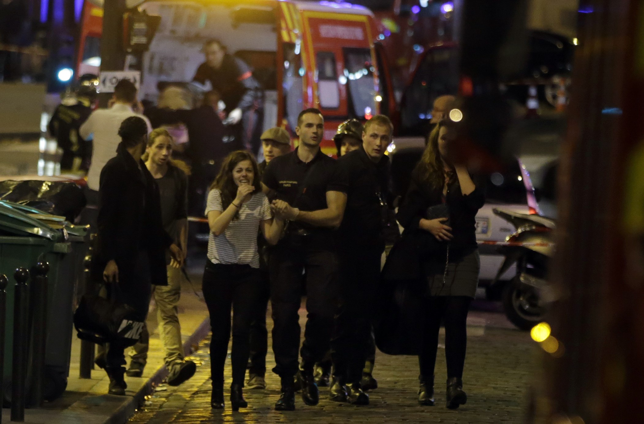 Rescue workers stand near Place de la Republique square in Paris on November 13, 2015. At least 18 people were killed in several shootings and explosions in Paris today, police said. AFP PHOTO / DOMINIQUE FAGET (Photo credit should read DOMINIQUE FAGET/AFP/Getty Images)