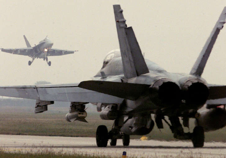 A Canadian F-18 Hornet fighter jet lands while another prepares to take off from the Italian-American NATO air base in Aviano in this October 12, 1998 file photo.
