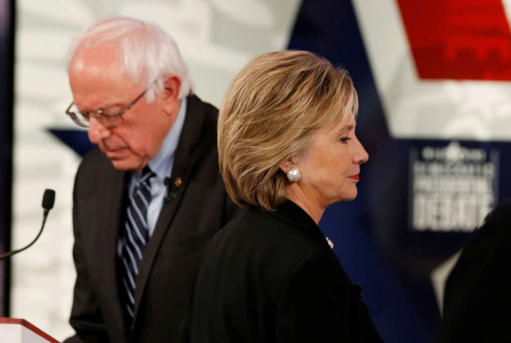 Democratic U.S. presidential candidate former Secretary of State Hillary Clinton walks past fellow candidate and Senator Bernie Sanders during a break at the second official 2016 U.S. Democratic presidential candidates debate in Des Moines, Iowa, November 14, 2015.