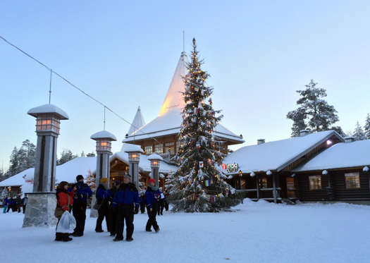 Visitors walk in Santa Claus Village, around 8 kms, 5 miles north of Rovaniemi in Finland on Tuesday Dec. 15, 2015. Most kids learn that Santa Claus comes from the North Pole, but children in Scandinavia are taught he lives a bit further south. Where exactly is a matter of much debate, with businesses in Finland, Sweden and Norway competing to cash in on the cache that comes with claiming Santa’s hometown. (AP Photo/James Brooks)