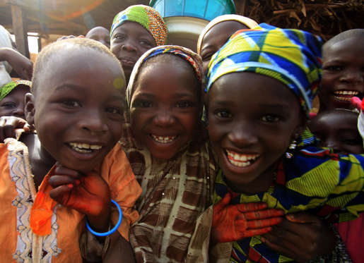 Children smile as they pose in the village of Dawakin Kudu near Kano November 28, 2009. REUTERS/Akintunde Akinleye (NIGERIA SOCIETY)