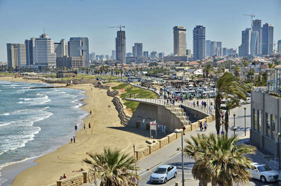 Jaffa, Israel - April 11, 2014: People on the Mediterranean beach and Tel Aviv, Israel boradwalk with the city sky line and towers in the background