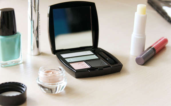 Set of eyeshadow and other cosmetics on a dressing table.