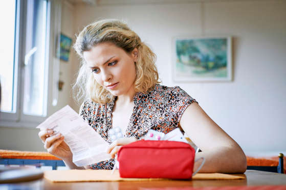 Woman reading medication instruction sheet, France.