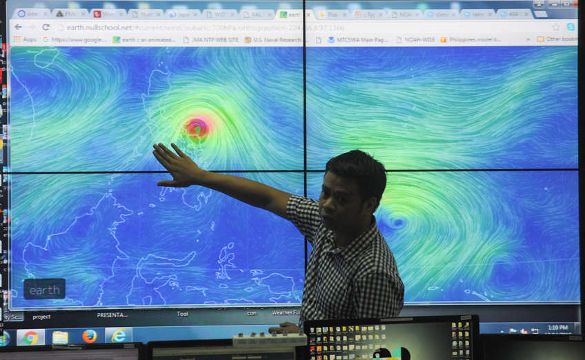 Meteorologists from the Philippine Atmospheric Geophysical and Astronomical Services Administration (PAGASA) monitor and plot the direction of powerful Typhoon Melor at their headquarters in suburban Manila on December 14, 2015. More than 700,000 people fled the central Philippines amid threats of giant waves, floods and landslides as powerful Typhoon Melor approached the archipelago nation, officials said on December 14.