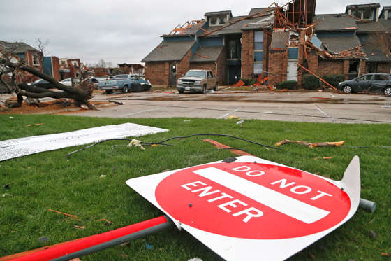A street sign lays bent to the ground at the Landmark at Lake Village North Apartments as the recovery process begins following tornadoes which hit the area late Saturday night December 28, 2015 in Garland, Texas. A meteorolocical assault of tornadoes, blizzards and heavy rain have left dozens dead and a large path of property damage in the Central, U.S.