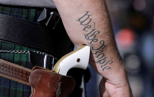 In this Jan. 26, 2015 file photo, Scott Smith, a supporter of open carry gun laws, wears a pistol as he prepares for a rally in support of open carry gun laws at the Capitol, in Austin, Texas. Texas the second-most populous state, is joining 44 other states in allowing at least some firearm owners to carry handguns openly in public places. Under the Texas law, guns can be carried by those with licenses and only in holsters. (AP Photo/Eric Gay, File)