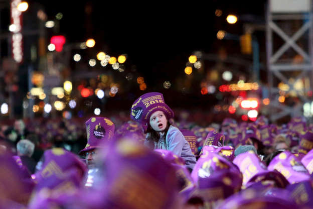 A child is lifted above the crowd during New Year celebrations in Times Square in the Manhattan borough of New York December 31, 2015. REUTERS/Andrew Kelly