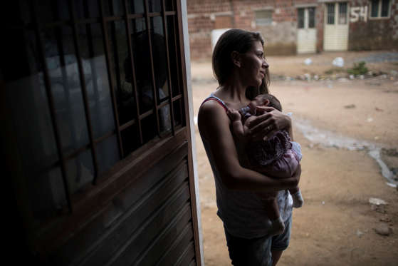 In this Dec. 22, 2015 photo, Angelica Pereira holds Luiza outside their house in Santa Cruz do Capibaribe, Pernambuco state, Brazil. Luiza was born in October with a rare condition, known as microcephaly. The Zika virus, first detected in humans about 40 years ago in Uganda, has long seen as a less-painful cousin to dengue and chikunguya, which are spread by the same Aedes mosquito. Until a few months ago, investigators had no reported evidence it might be related to microcephaly. (AP Photo/Felipe Dana)