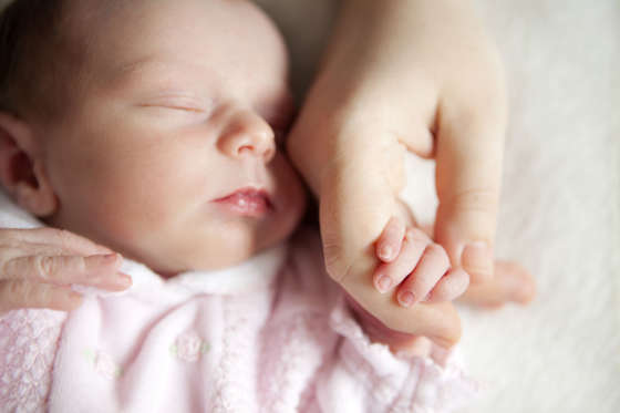 Новородено бебе държеше ръката на майка си