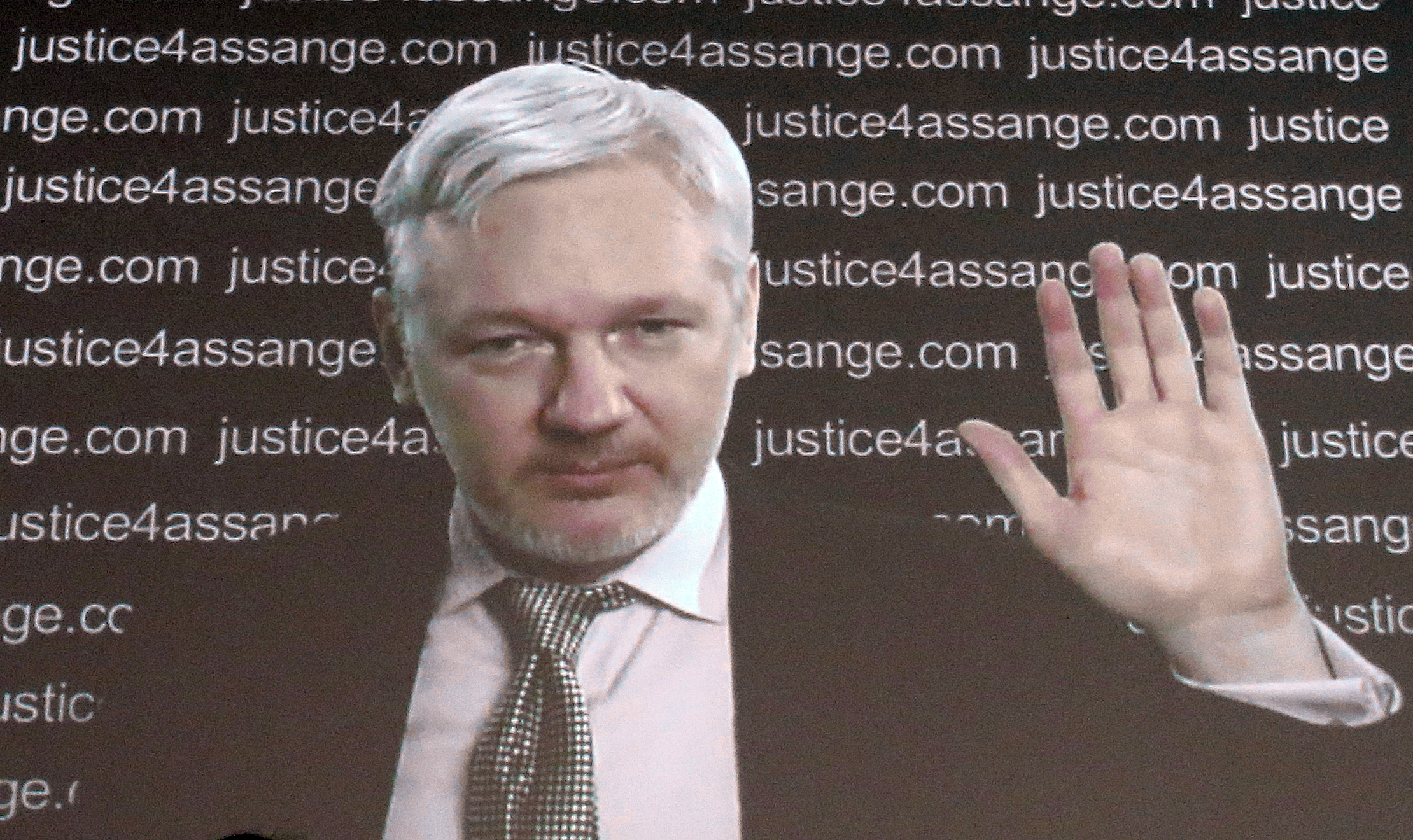 WikiLeaks founder Julian Assange is seen on a screen as he addresses the media from the London embassy of Ecuador Friday Feb. 5, 2016, where he has been holed up for some 3½ years to avoid extradition to Sweden for questioning about alleged sexual offenses. A U.N. human rights panel says Assange has been "arbitrarily detained" by Britain and Sweden since December 2010. The U.N. Working Group on Arbitrary Detention said his detention should end and he should be entitled to compensation.