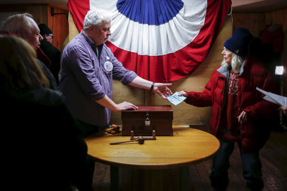 Resident Nancy Holmes, 77, hands her ballot to town moderator Leslie Schoof as she votes in New Hampshire's first-in-the-nation primary at the town hall in Hart's Location, New Hampshire, February 9, 2016. The community of Hart's Location is one of three tiny New Hampshire towns that cast the state's first votes of the primary, as the clock strikes midnight.  Adrees Latif/Reuters