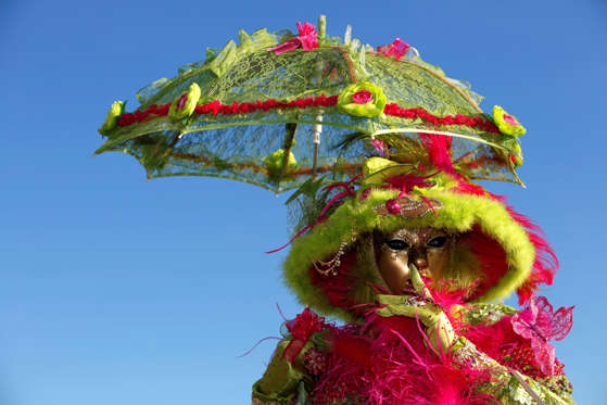 A costumed reveller wearing a volto mask poses for a photograph at St Marks Square during the 2016 Carnevale di Venezia, in Venice, Italy, on Friday, Feb. 5, 2016. The annual Venice Carnival runs for ten days, ending on the Christian celebration of Lent.