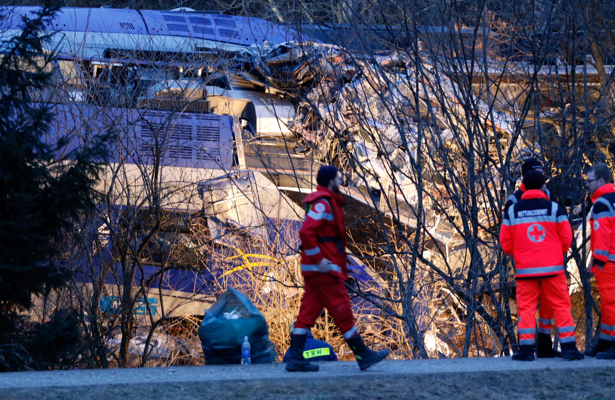 Members of emergency services stand next to a crashed train near Bad Aibling in ...