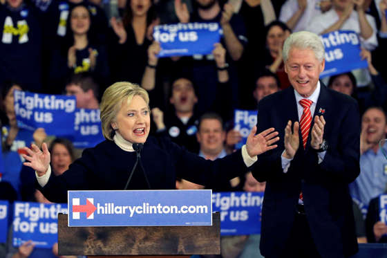 Democratic presidential candidate Hillary Clinton speaks as former President Bill Clinton applauds at her New Hampshire presidential primary campaign rally, Tuesday, Feb. 9, 2016, in Hooksett, N.H.