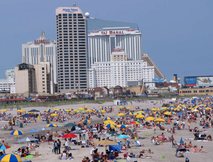 In this July 3, 2015 photo, beach goers sunbath in front of casinos in Atlantic City, N.J.