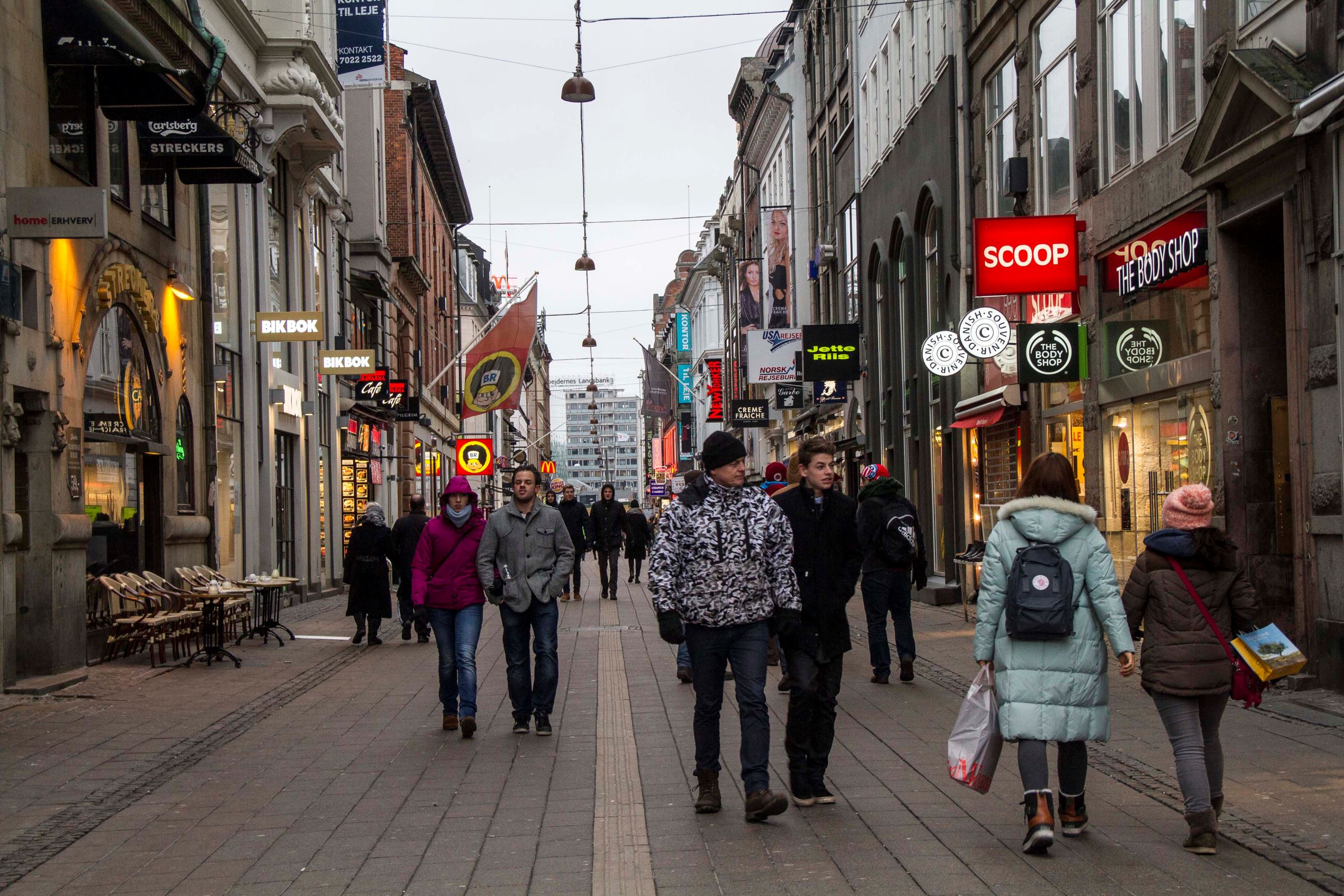 Pedestrians pass retail stores on Stroeget shopping street in Copenhagen, Denmark, on Sunday, Jan. 19, 2014.