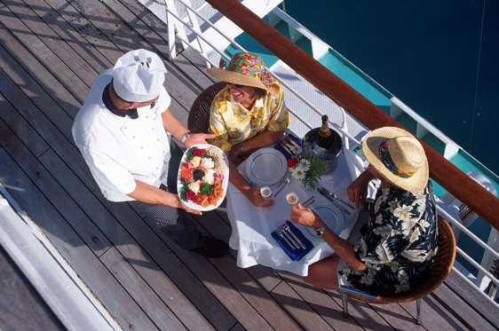 Couple receiving meal on deck of passenger liner