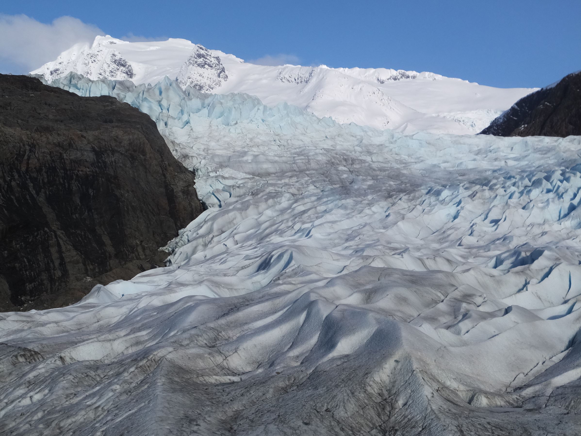 File - In this Feb. 15, 2016 file photo, snow-covered mountains are seen behind the Mendenhall Glacier in Juneau, Alaska. The massive Alaska ice field that feeds Juneau's Mendenhall Glacier, a tourist attraction viewed by hundreds of thousands each year, could be gone by 2200 if climate warming trends continue, according to a new University of Alaska Fairbanks study.