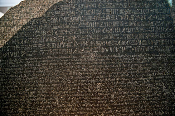 The Rosetta Stone is an ancient Egyptian granodiorite stele inscribed with a decree issued at Memphis in 196 BC on behalf of King Ptolemy V. The decree appears in three scripts: the upper text is Ancient Egyptian hieroglyphs, the middle portion Demotic script, and the lowest Ancient Greek. Because it presents essentially the same text in all three scripts (with some minor differences between them), it provided the key to the modern understanding of Egyptian hieroglyphs.