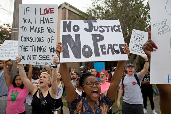 Police and protesters demonstrate in a residential neighborhood in Baton Rouge, La. on Sunday, July 10, 2016.