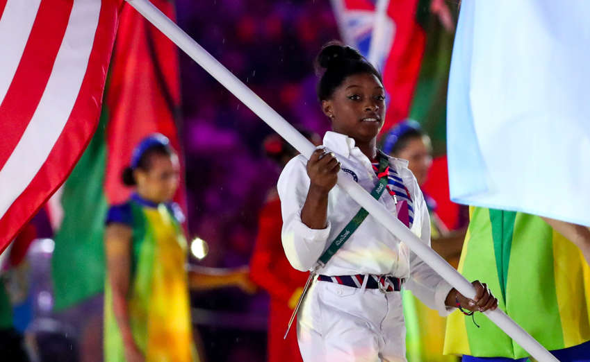 Simone Biles (USA) carries the flag during the march of the heroes.