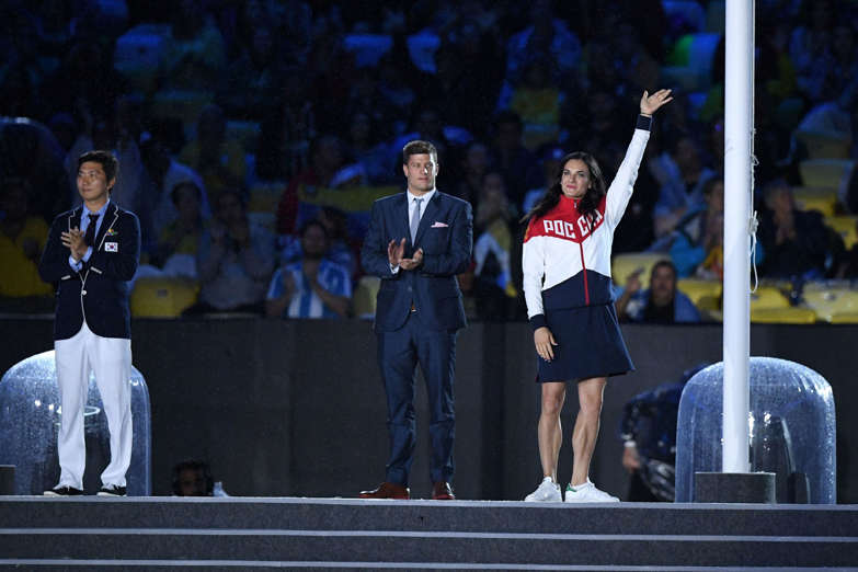 Newly elected member of the IOC Athletes Commission former Russian pole vaulter Yelena Isinbayeva (R) waves during the closing ceremony of the Rio 2016 Olympic Games at the Maracana stadium in Rio de Janeiro on August 21, 2016.