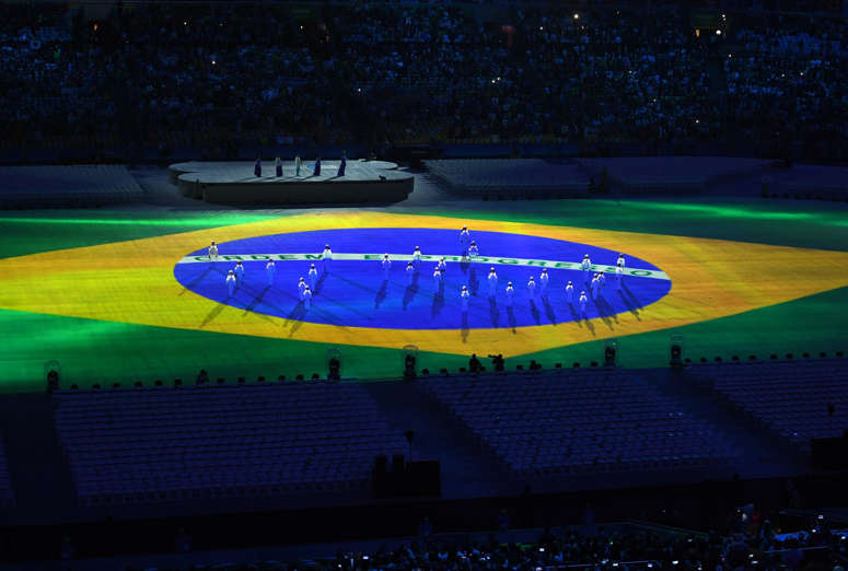 The Brazilian flag is projected on the floor of the stadium.