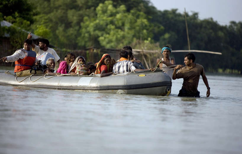 A navy personell pulls a boat as he rescue flood victims marooned for the past15 days after the Kosi river flooded in Purnea Dist, Bihar, India, on Wednesday, Sep. 3, 2008.