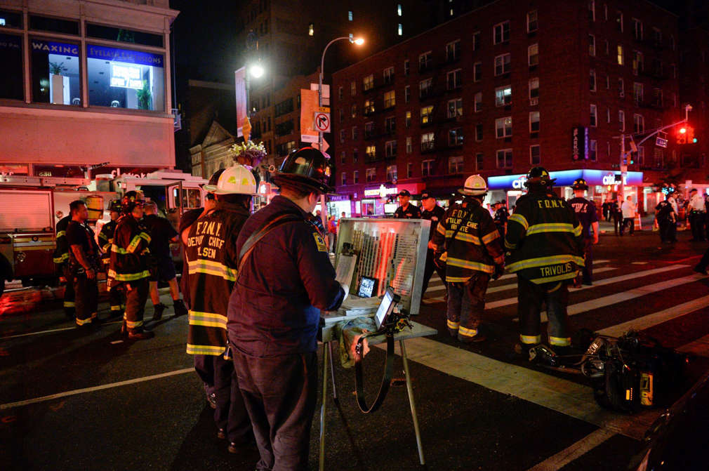 New York City police and firefighters stand near the site of an explosion in the Chelsea neighborhood of Manhattan, New York, U.S. September 17, 2016.