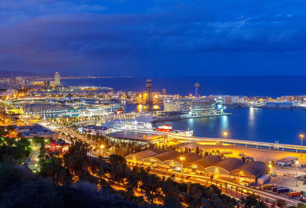 View of Barcelona and the sea port with Montjuk hill at sunset.