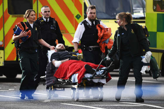 Slide 21 of 34: A member of the public is treated by emergency services near Westminster Bridge and the Houses of Parliament on March 22, 2017 in London, England. A police officer has been stabbed near to the British Parliament and the alleged assailant shot by armed police. Scotland Yard report they have been called to an incident on Westminster Bridge where several people have been injured by a car.