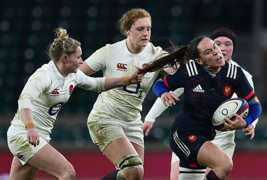 Slide 6 of 34: TOPSHOT - France's scrum half Jade Le Pesq (R) has her hair pulled by England's scrum-half Natasha Hunt (L) during the Six Nations international women's rugby union match between England Women and France Women at Twickenham stadium in south west London o