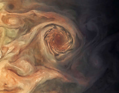 Slide 8 of 11: This image, taken by the JunoCam imager on NASA’s Juno spacecraft, highlights a swirling storm just south of one of the white oval storms on Jupiter.