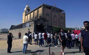 People stand outside the Anba Bishoy Church after a fire broke out, in New Minya governorate, Egypt, on Tuesday. The fire, which reportedly broke out due to an electrical short circuit, occurred two days after a blaze at the Abu Sefein Coptic Church in Giza killed 41 people. EPA