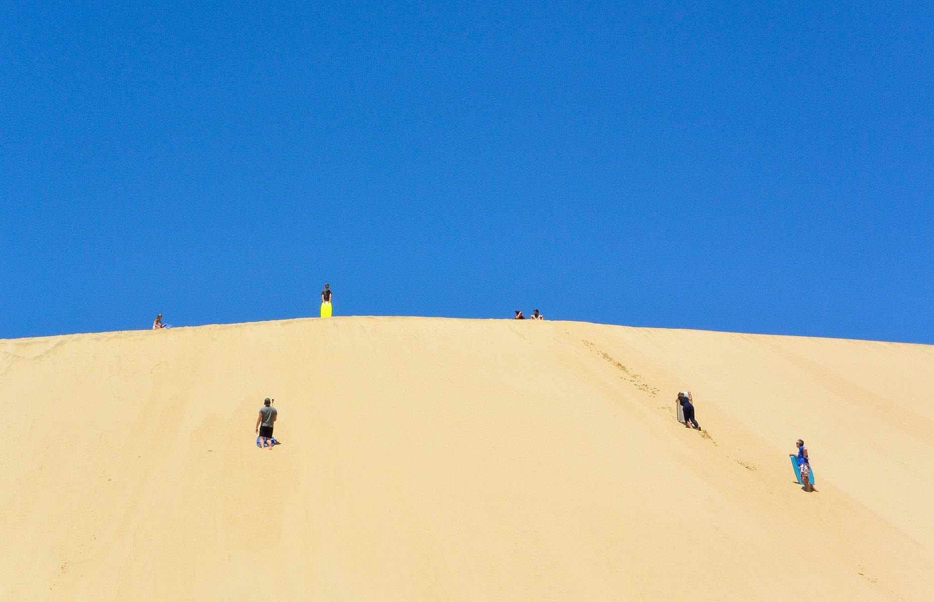 Sandboarding on New Zealand’s Giant Sand Dunes is some of the best fun you’ll have on a trip to New Zealand. Nowhere is better than the towering sand dunes at this recreation area, en route to Cape Reinga in the far north of the North Island. Boards can be hired in the car park and you walk them up to the top of the slope before speeding down on your belly.
