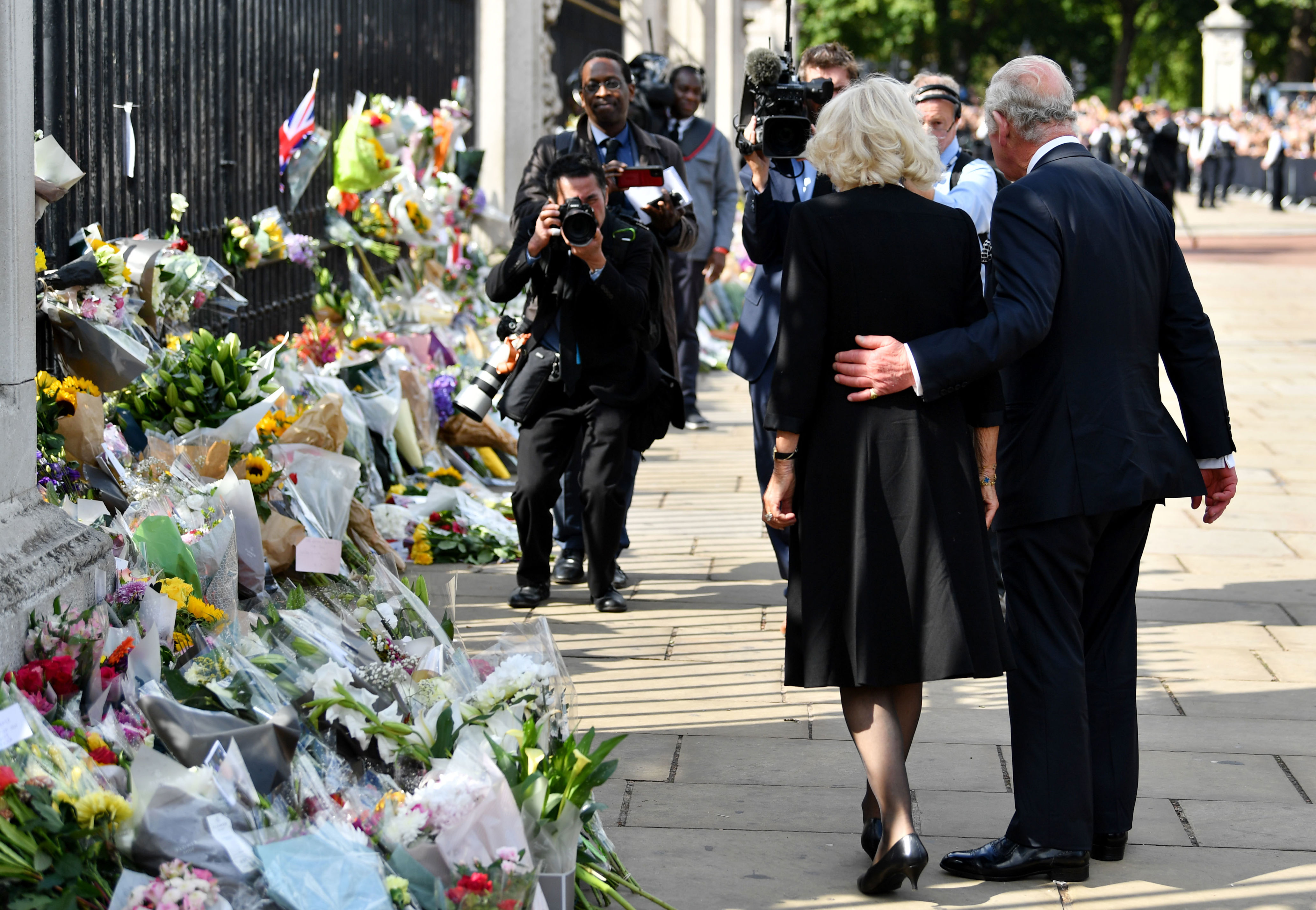 <p>King Charles III put a loving arm around his wife, Camilla, Queen Consort, as they took in the tributes left for his mother, Queen Elizabeth II, outside Buckingham Palace in London on Sept. 9, 2022, the morning after <a href="https://www.wonderwall.com/celebrity/celebrities-dignitaries-react-to-death-of-queen-elizabeth-ii-647756.gallery">the monarch who spent 70 years on the throne died in Scotland</a>.</p>