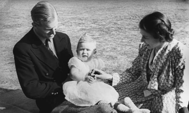 A young Prince Charles is perched on the lap of his father the Duke of Edinburgh, while his mother Queen Elizabeth II looks on in the grounds of Windlesham Moor in 1949. All photos: Getty Images