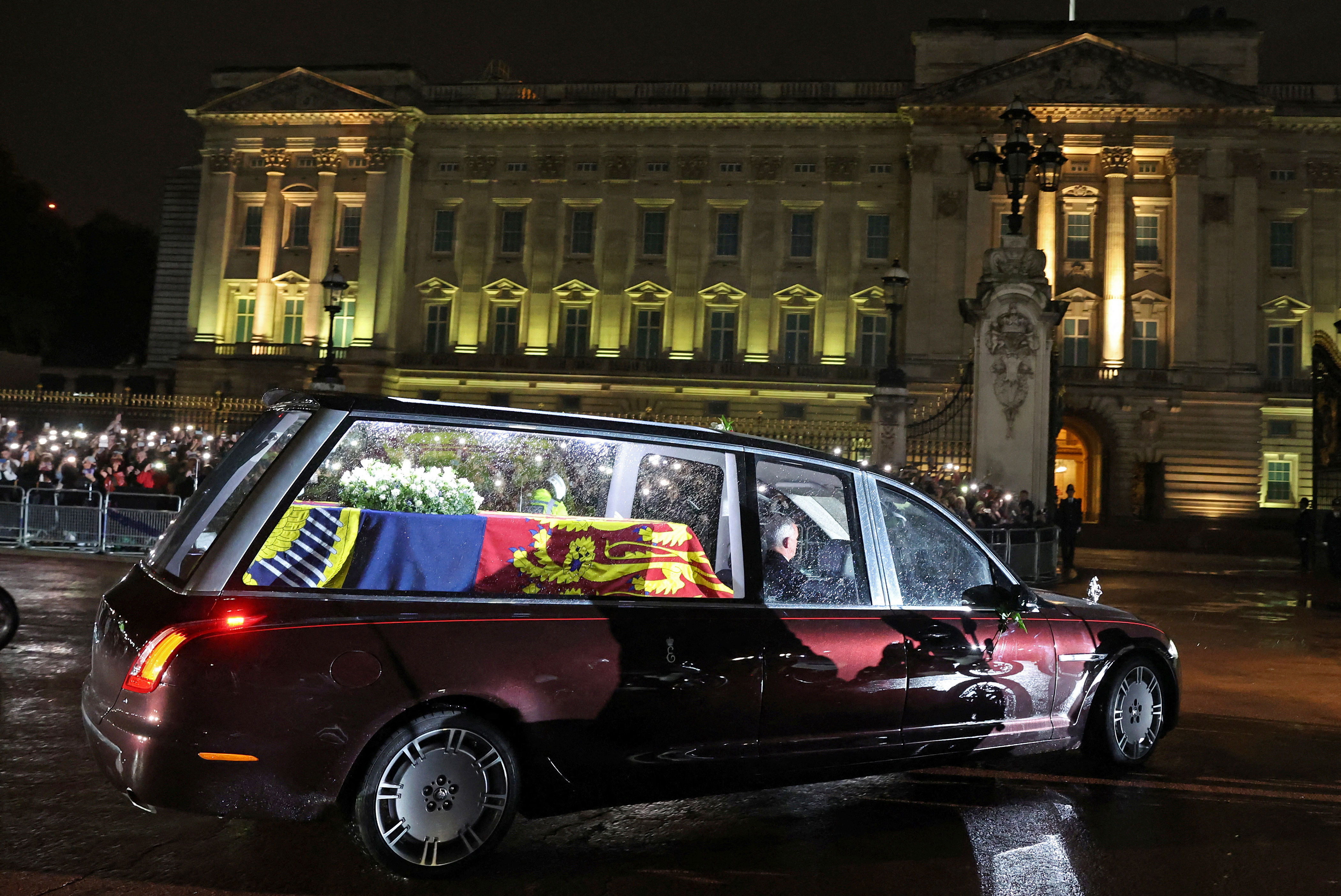 <p>A new state hearse featuring tall glass windows and interior lights -- which was designed in consultation with the late Queen Elizabeth II -- carried her coffin to Buckingham Palace in London on Sept. 13, 2022, after it arrived via plane from Scotland. King Charles III, his siblings and their children and spouses were waiting inside the palace gates to greet the cortege of vehicles before Her Majesty's body was taken to the Bow Room, where it would remain overnight.</p>