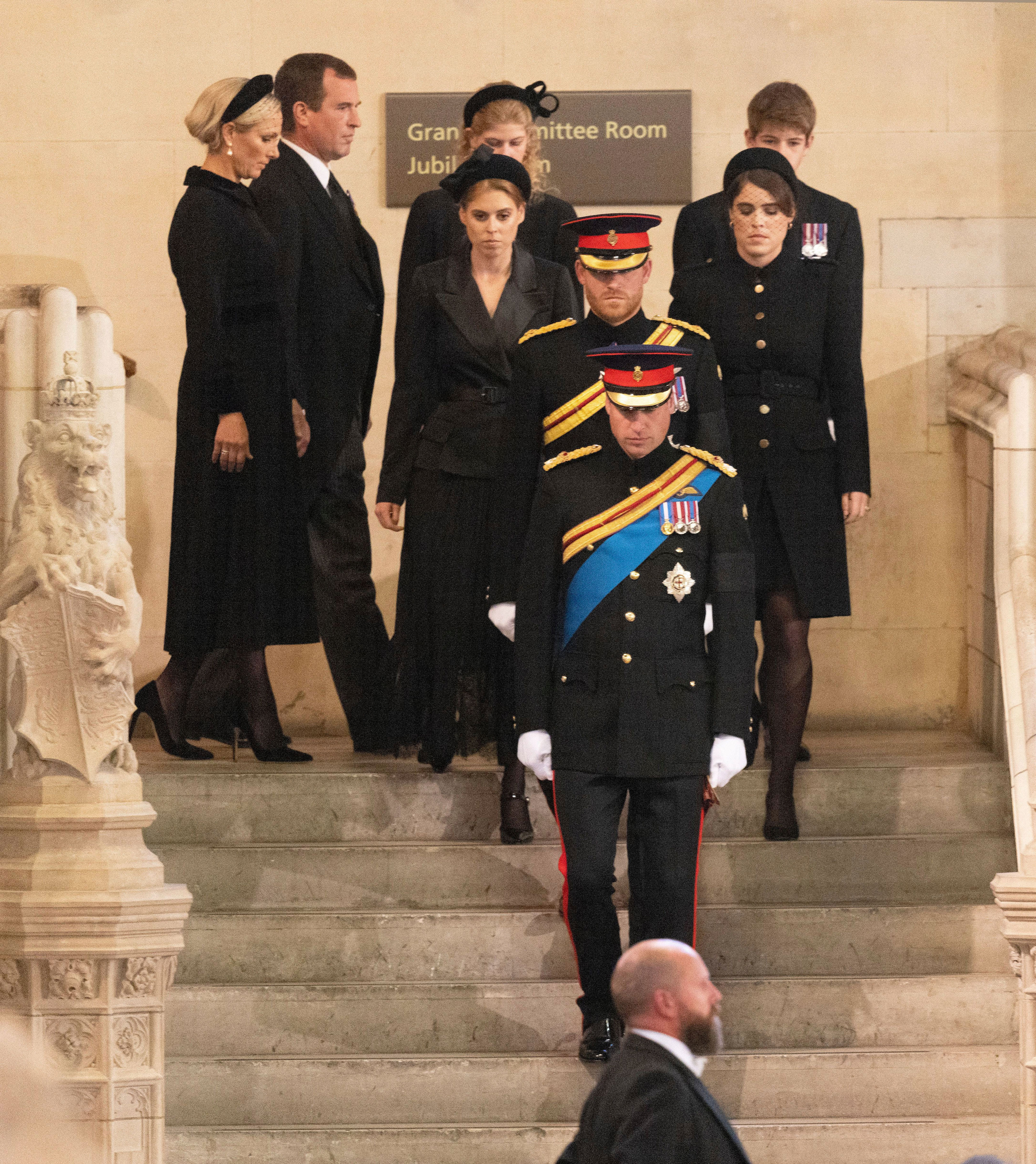 <p>Queen Elizabeth II's grandchildren -- Zara Tindall and brother Peter Phillips; Lady Louise Windsor and brother James, Viscount Severn; Princess Beatrice and sister Princess Eugenie; and <a href="https://www.wonderwall.com/celebrity/profiles/overview/prince-william-482.article">Prince William</a> and brother <a href="https://www.wonderwall.com/celebrity/profiles/overview/prince-harry-481.article">Prince Harry</a> -- made their way down a staircase in Westminster Hall at the Palace of Westminster in London on Sept. 17, 2022, during the late monarch's lying-in-state before taking their places around her coffin to hold vigil two days before her funeral.</p>