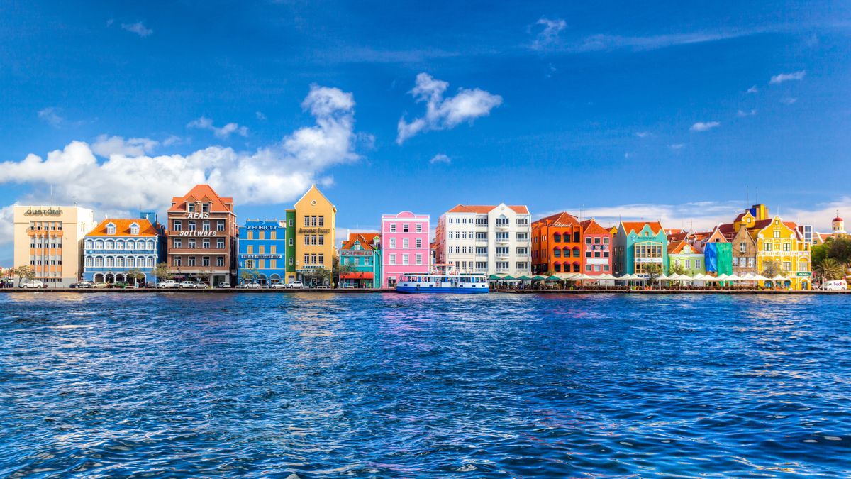<p>Unlike most, Curacao is a Dutch island so you won’t come across many Americans. Like a real-life diorama, buildings of businesses and residences are painted vibrant colors that have become signature to the island. You’re not allowed to paint your home black though! </p><p>A short drive out of the city awaits beaches with crystal clear blue water, coves, coral reefs and more. Known for some of the best diving in the world, swim among giant but friendly sea turtles and other marine life. </p><p>Where to stay: <a href="https://www.corendonhotels.com/corendon-mangrove-beach-resort/">The Corendon Mangrove Beach Resort</a> encapsulates the island with its own private beachfront, pools, local beer and even theme park sized water slides! Most importantly, it’s location is right near the colorful downtown.</p>