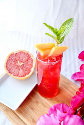 Raspberry grapefruit cocktail garnished with cantaloupe slices. 