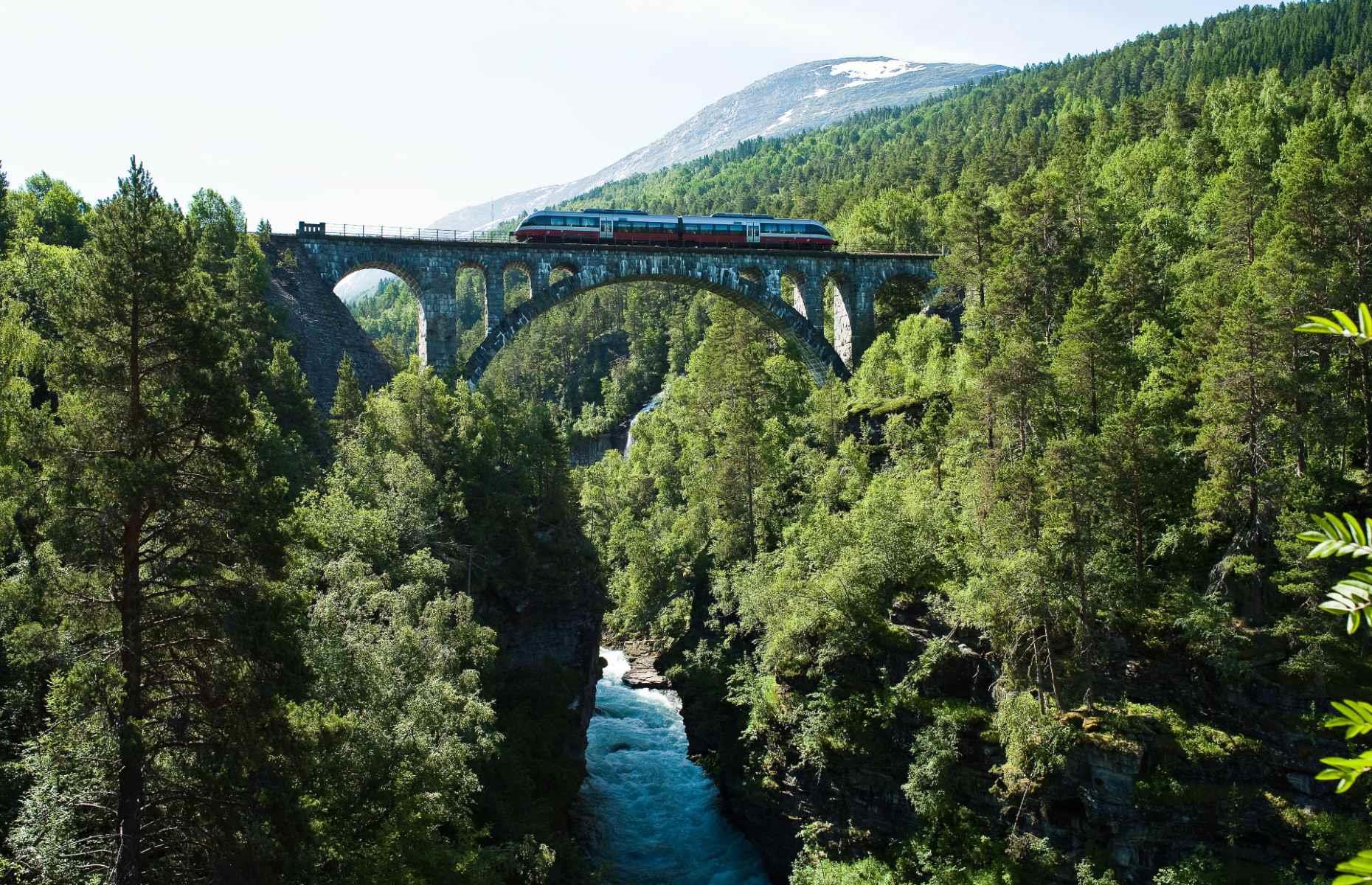 <p>Few places on Earth have as much dramatic scenery as Norway and the <a href="https://www.visitnorway.com/plan-your-trip/getting-around/by-train/rauma-line/">Rauma Line</a> is a great way to experience it. The one hour and 40-minute journey begins in the village of  Dombås, taking in the historic towns and mountain farms of the Gudbrandsdalen valley before entering the steep and rugged Romsdalen valley. It then passes over the famous Kylling Bridge and cruises past Trollveggen mountain before arriving at its final destination, Åndalsnes.</p>