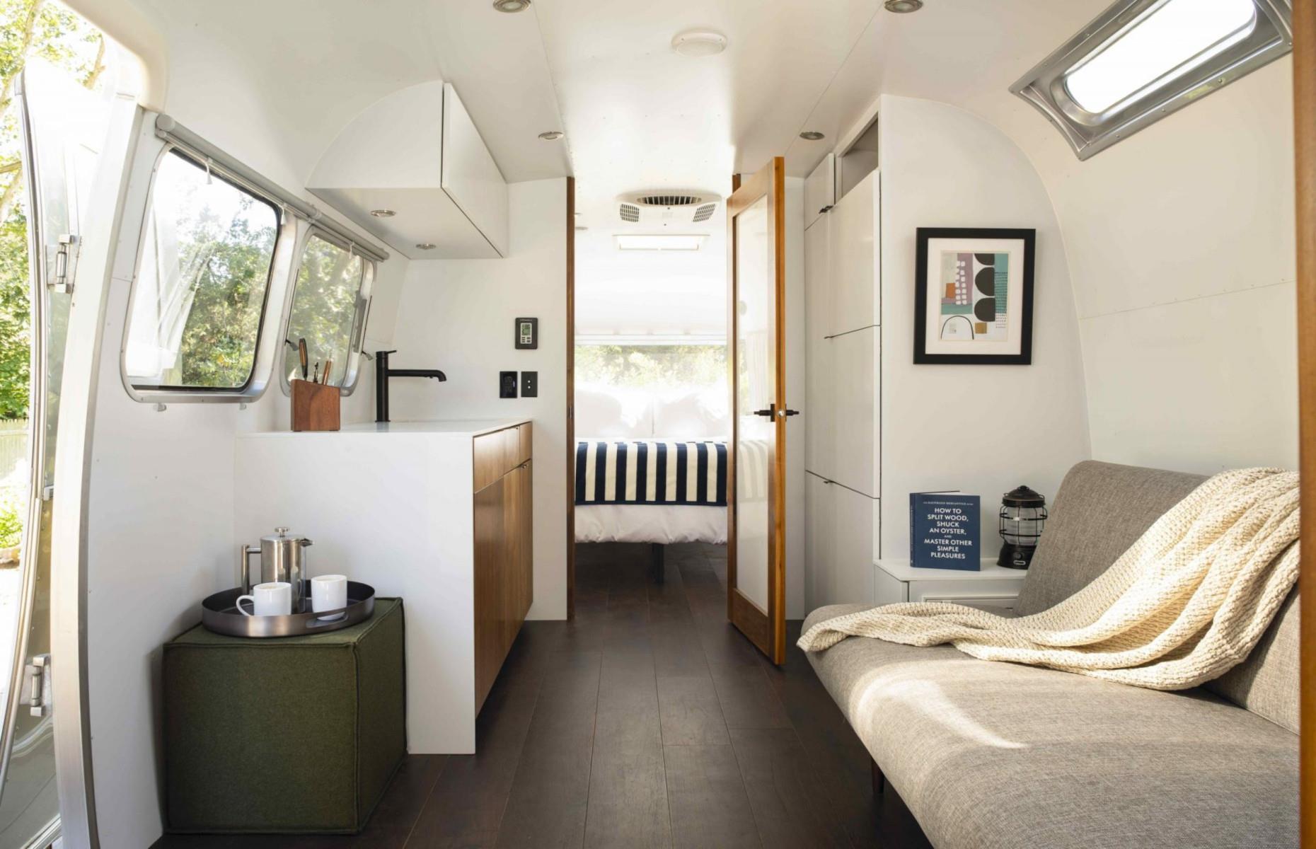 <p>The spacious 31-foot Airstream can sleep up to three adults, or two adults and two children. The interior is bright and airy, with a neutral white color scheme and pared-back furnishings. Outside, the outdoor patio includes a firepit and a dining area. </p>