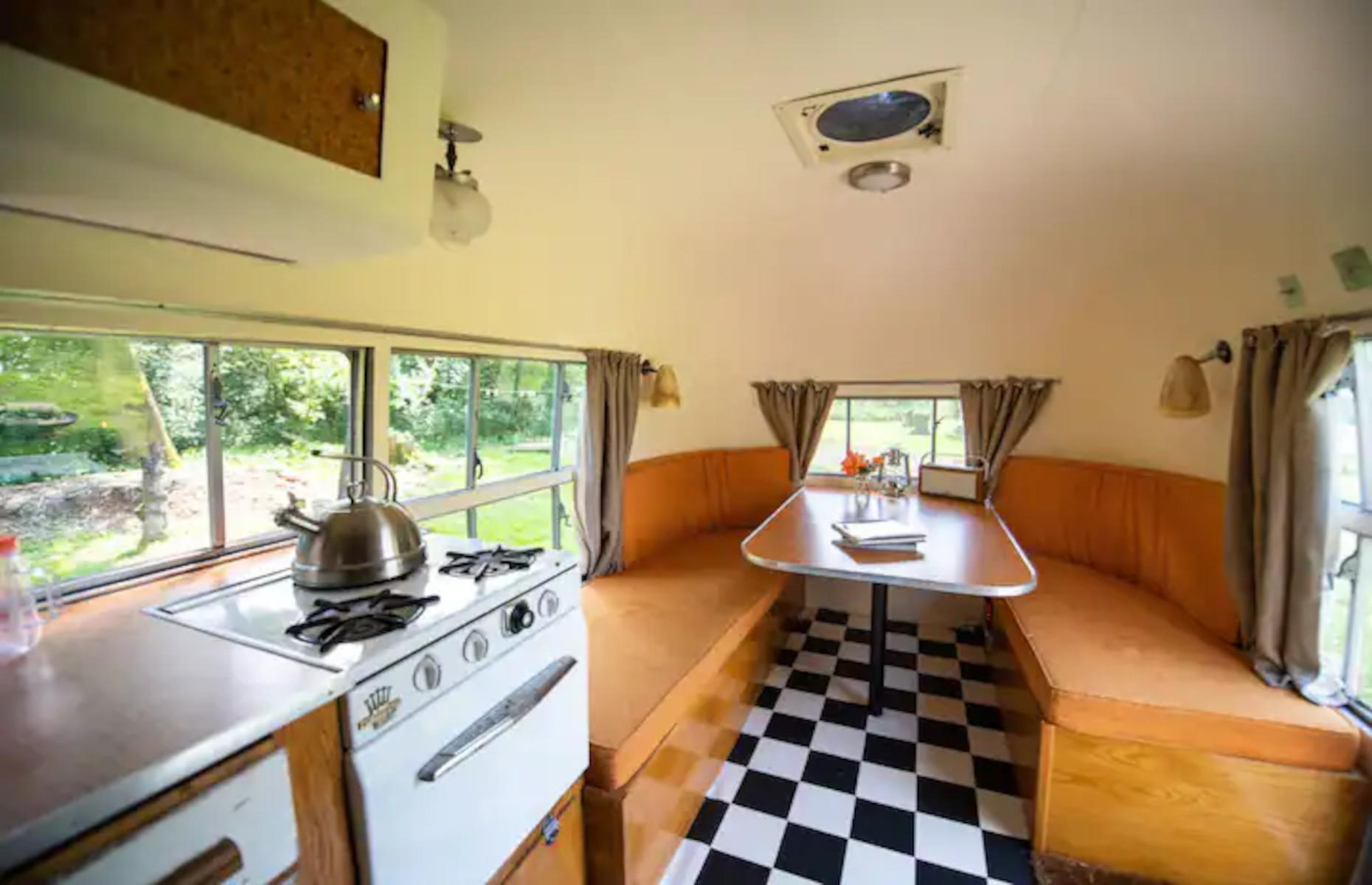<p>The Airstream has been lovingly restored to combine modern amenities with retro touches, including a <a href="https://www.loveproperty.com/gallerylist/89109/retro-kitchens-of-yesteryear-that-will-make-you-nostalgic">vintage but fully functioning kitchenette</a>, a bathroom consisting of a toilet and shower, a cozy double bed, and a cute seating area that looks like it was lifted straight out of a 1950s diner. These benches can also double as two extra twin beds if the kids are along for the ride! </p>